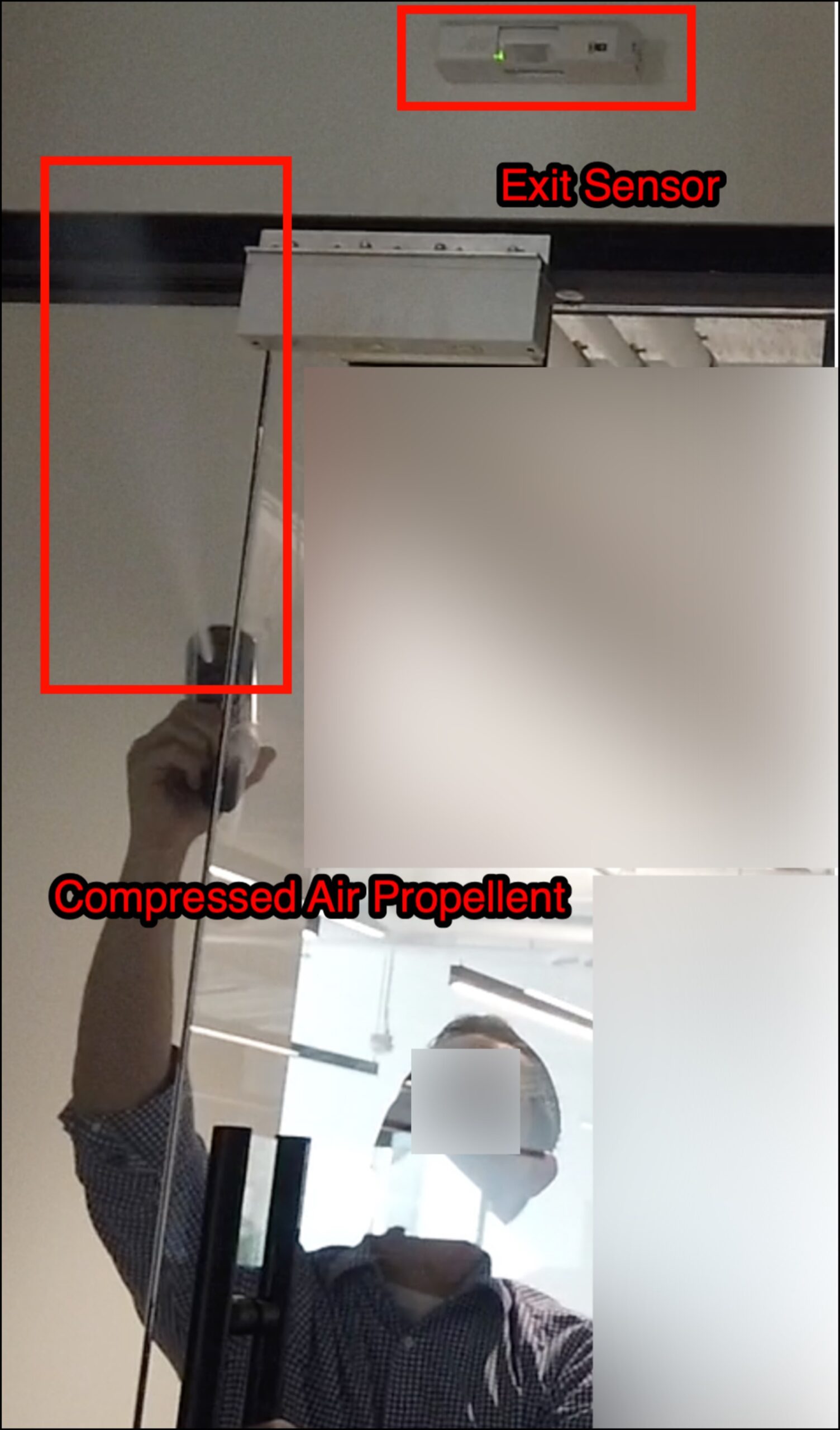 Compressed air duster positioned at the gap between the door and the adjacent glass sidelight panel, straw nozzle inserted through the gap and angled toward the interior REX sensor dome